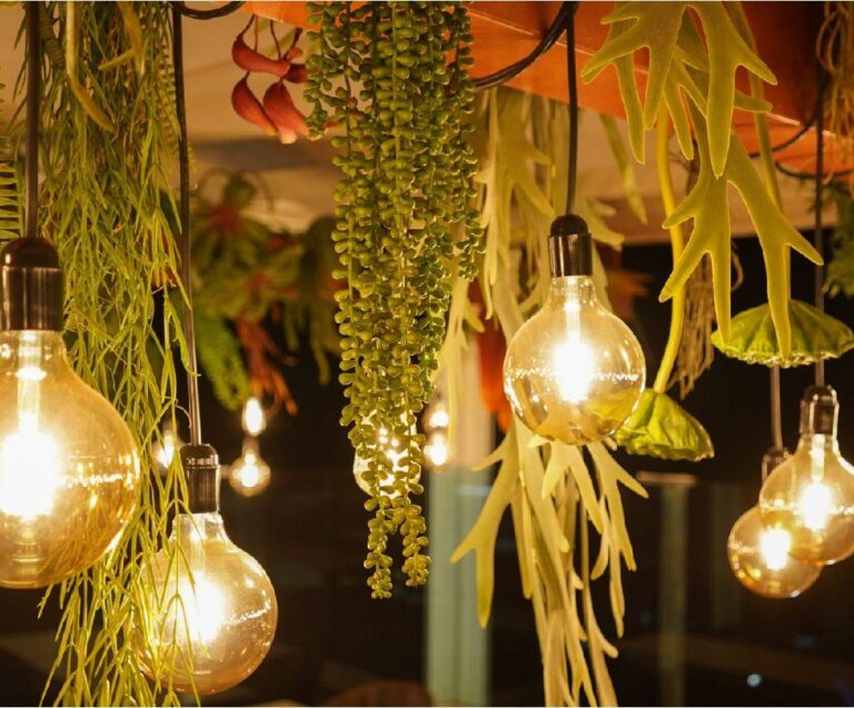 Detalle de plantas colgantes artificiales combinadas con bombillas decorativas